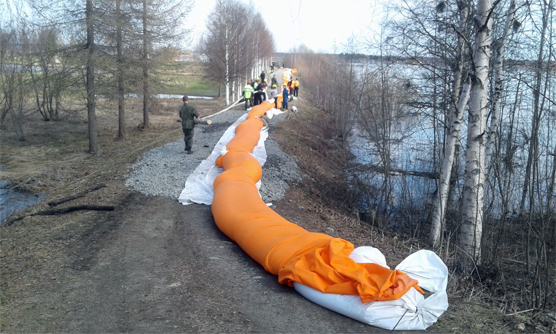 Tulvapuomin levittäminen ja vedellä täyttäminen käynnissä Tornion tulvapenkereellä. Kuva: Timo Alaraudanjoki